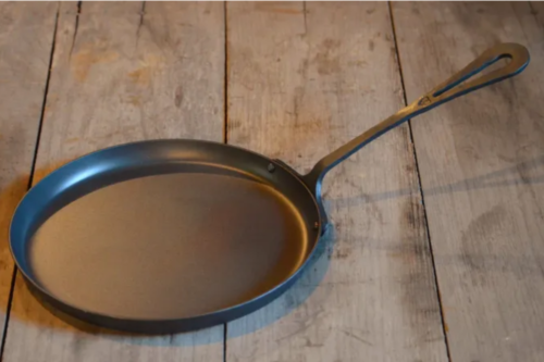 Freshly forged griddle on a wood table