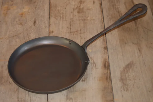 Hand forged griddle on a wood table